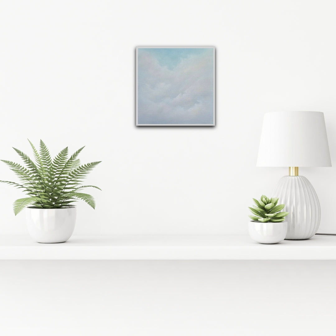 Modern interior with a lamp, plants, and a cloud painting on a white wall.
