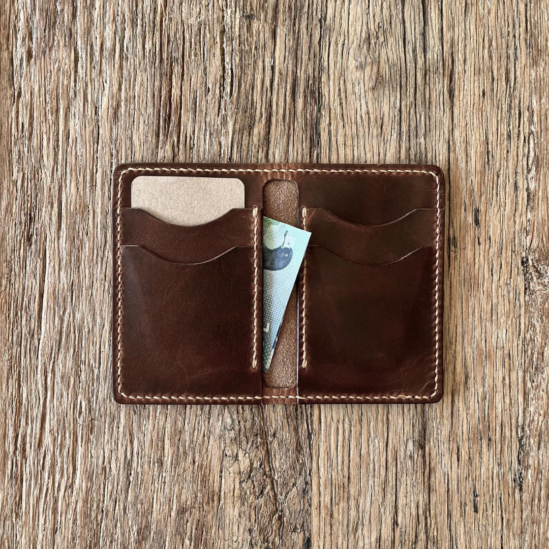 Brown leather wallet with card slots on a wooden surface