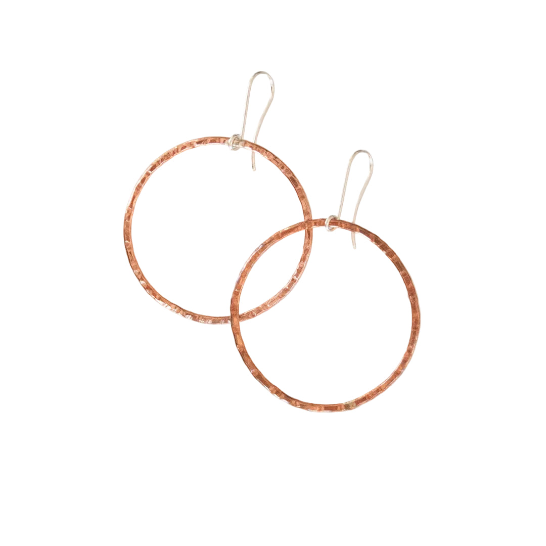 Pair of copper hoop earrings on a white background