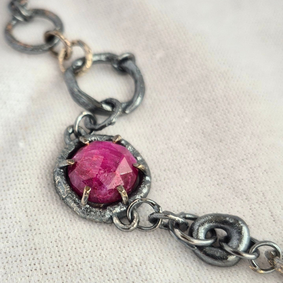 Silver necklace with a pink ruby on a white background