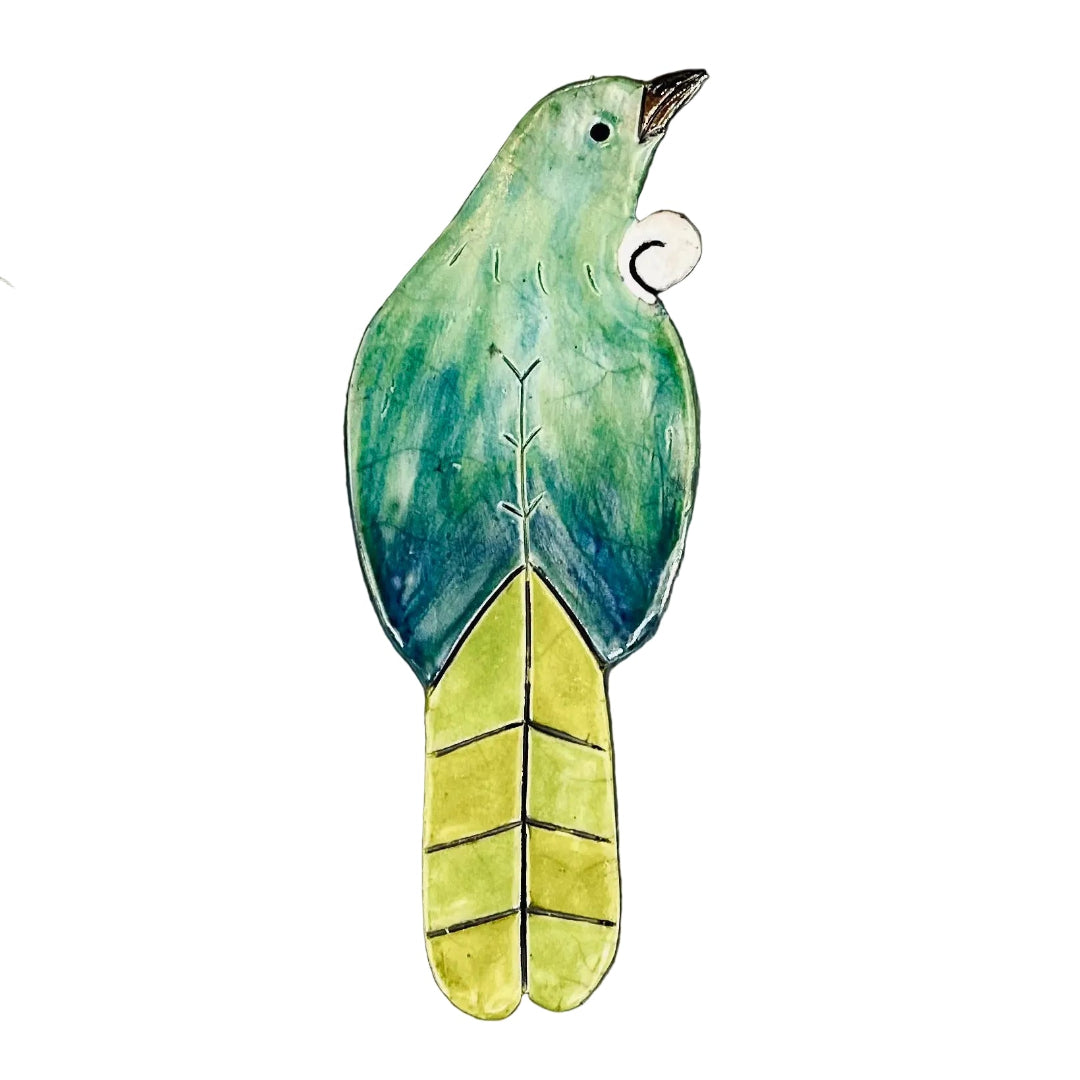 Decorative bird-shaped ceramic wall tile with a tui bird design on a white surface