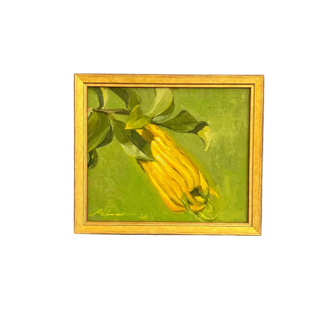 A small framed painting of a yellow fruit on a green background against a white background.