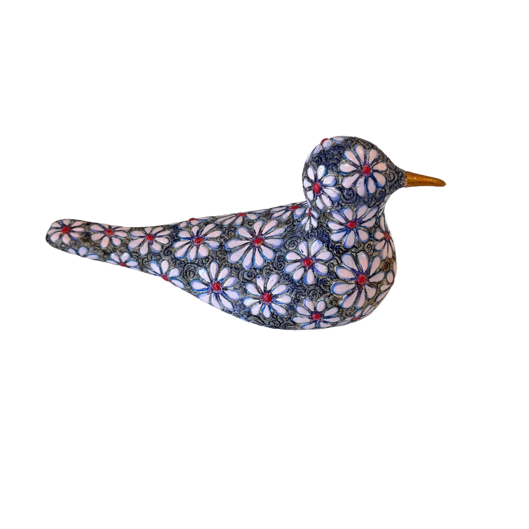 A decorative bird figurine with a detailed floral pattern in navy blue, white, and red, featuring a small gold beak, set against a plain white background.