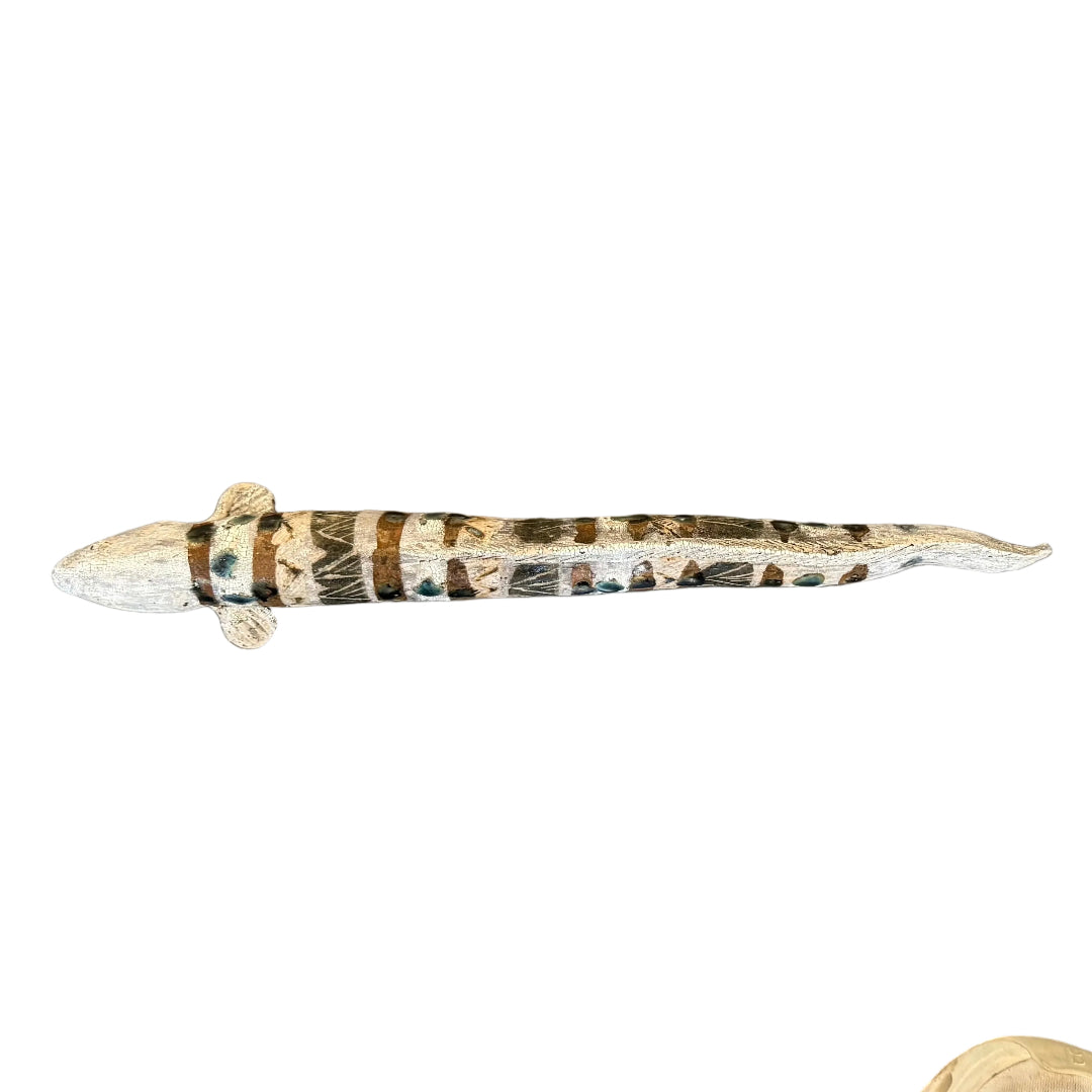 A top view of a ceramic sculpture of an eel with natural colorful patterns.