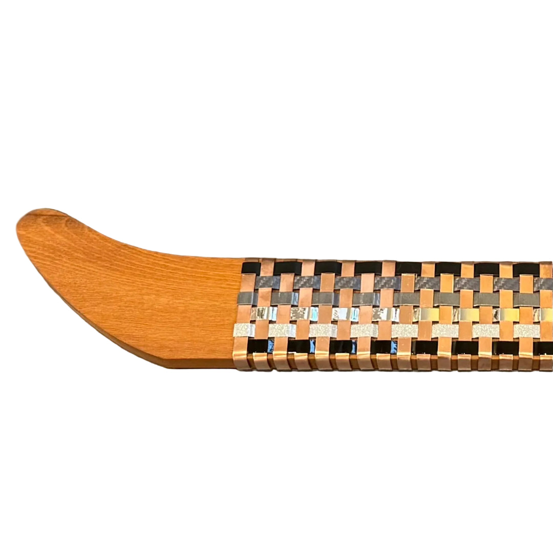 Close up view of a wooden wall waka with woven copper & aluminium on a white surface