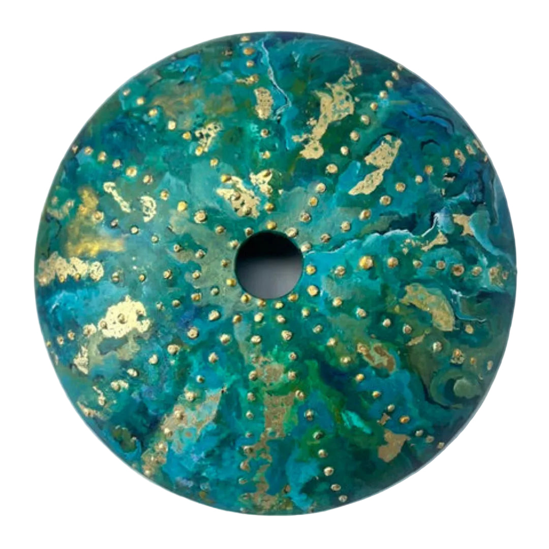 Decorative glass disc with teal and gold design on a white background