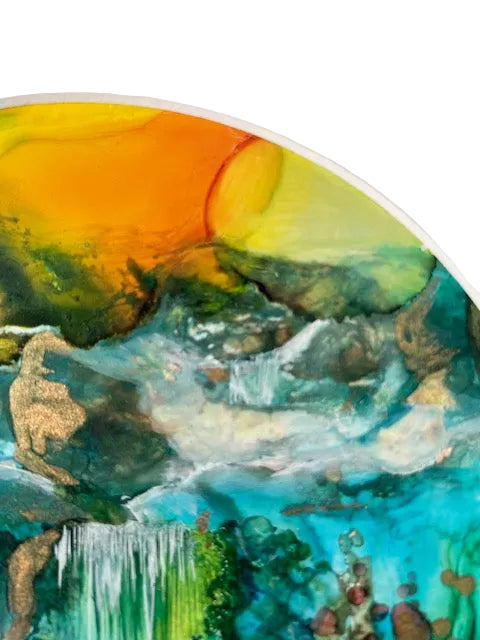 Close-up of a round colorful abstract painting with vibrant hues on a white background