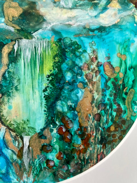 Close-up of a round painting with green, brown, and blue colors