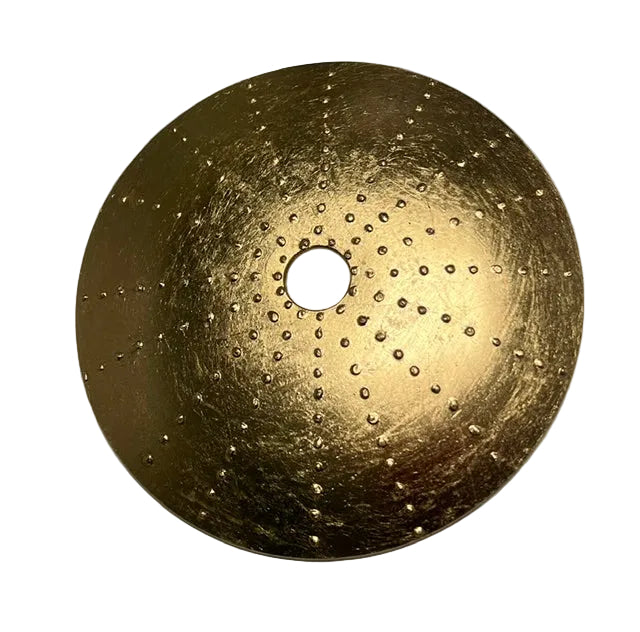 Gold leaf on glass disc with a central hole on a white background