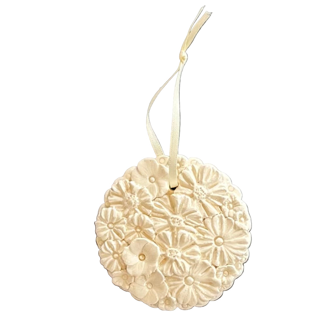 Decorative white ceramic round ornament with floral patterns on a white background