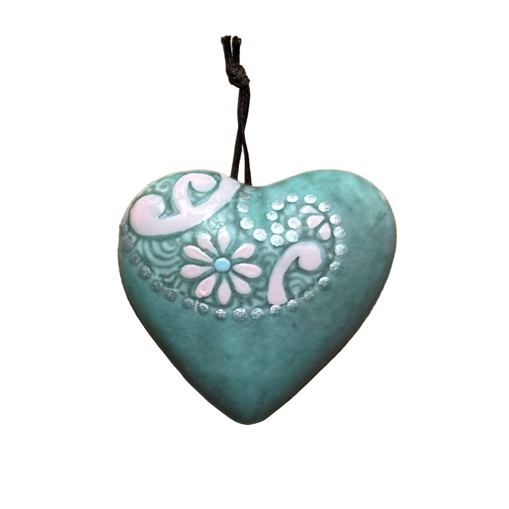 Turquoise ceramic hanging heart with silver embossing on a white surface