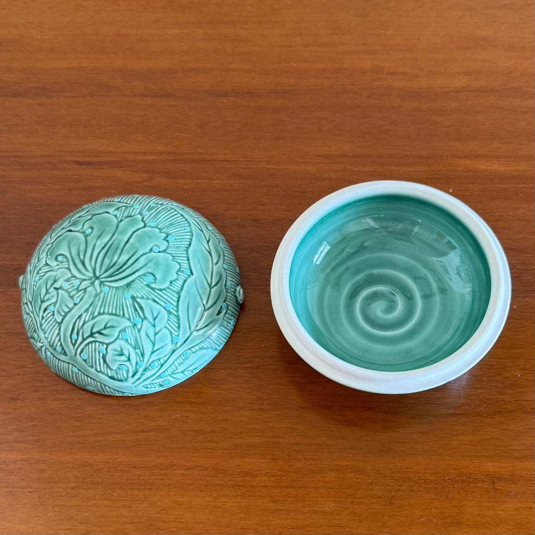Ceramic dish with lid with decorative patterns on a wooden surface
