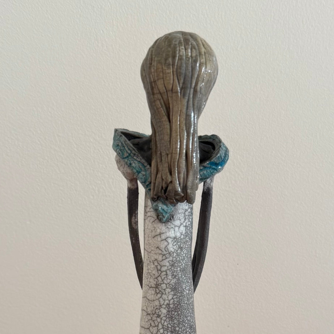 Ceramic figure with a crackle glaze on a plain background