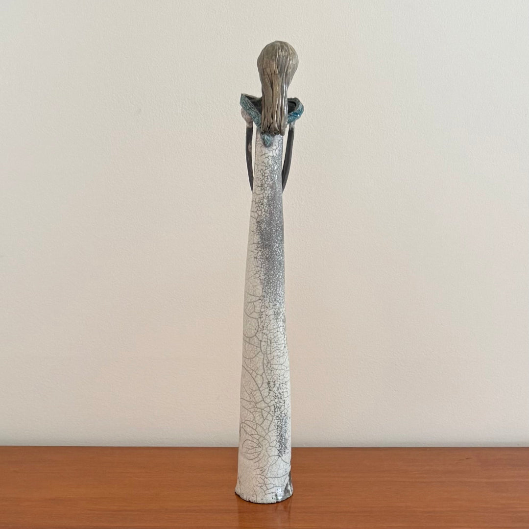 Ceramic figure with textured surface on a wooden surface