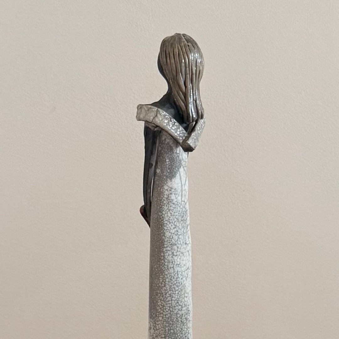 Ceramic figurine of a woman with a plain background
