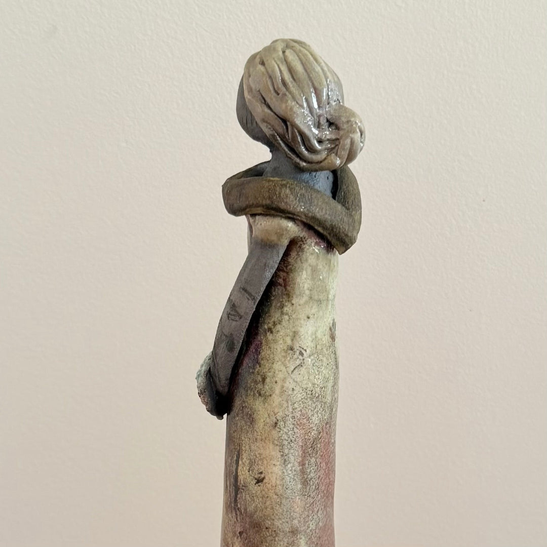 Decorative ceramic sculpture of a woman on a plain background