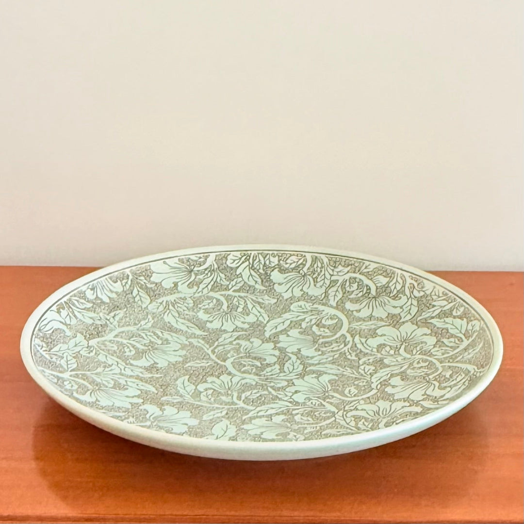 Decorative plate with floral pattern on a wooden surface