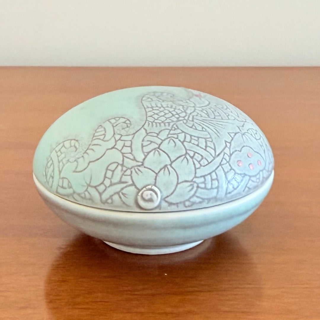 Ceramic container with floral patterns on a wooden surface