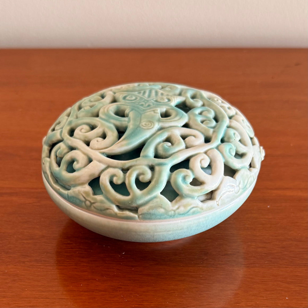 Decorative ceramic bowl with lid with  intricate patterns on a wooden surface