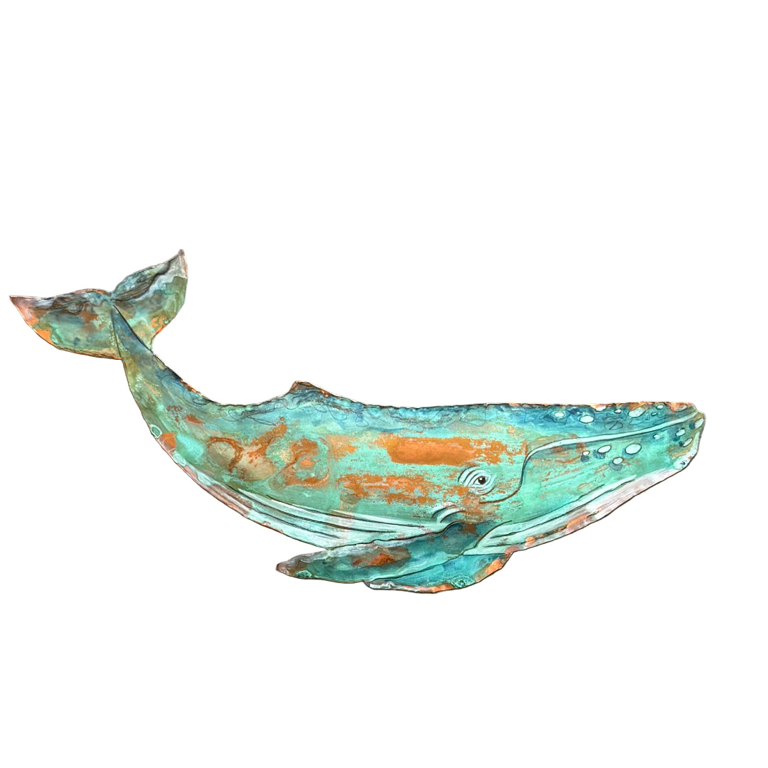 Decorative copper whale sculpture on white background