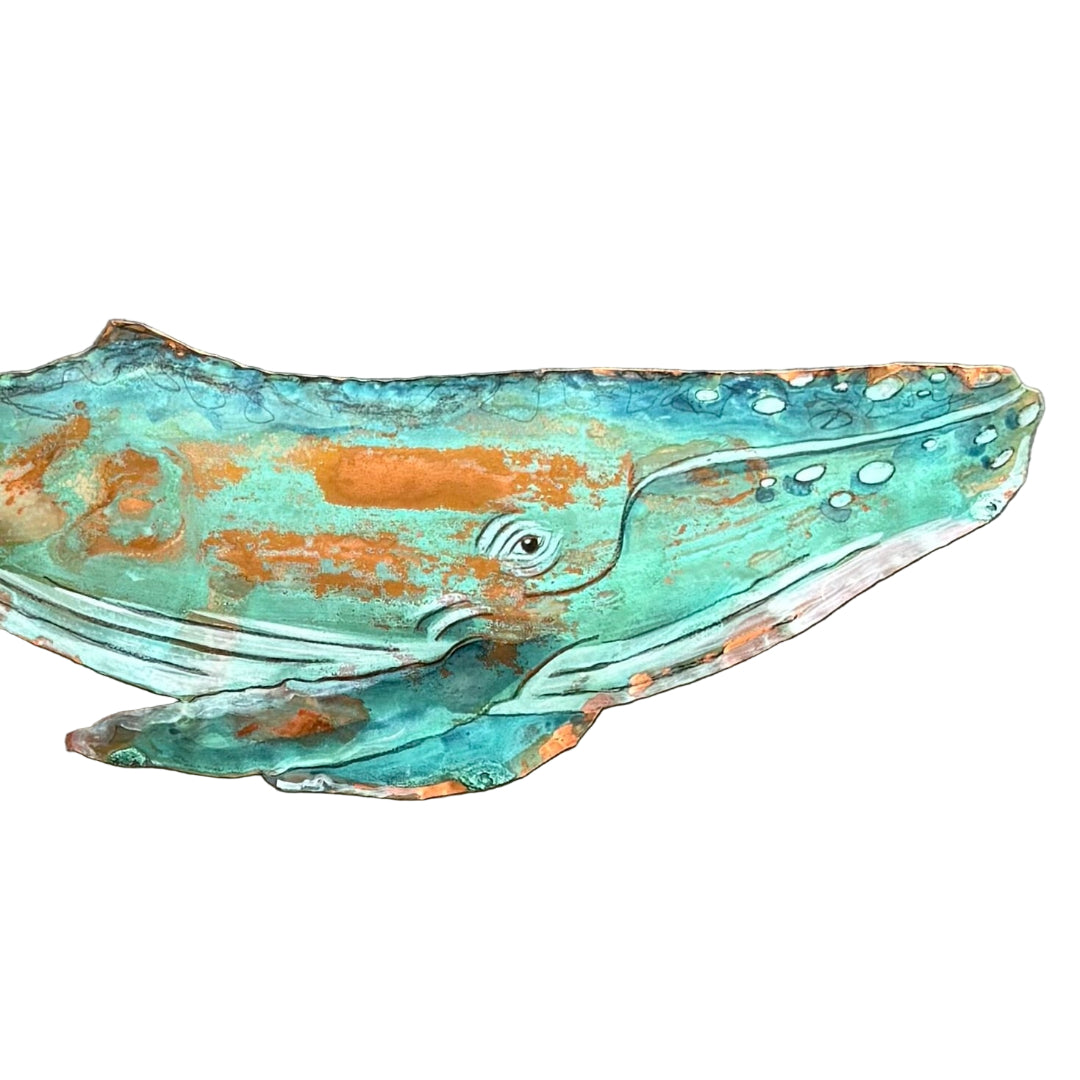 Decorative copper whale sculpture on a white background