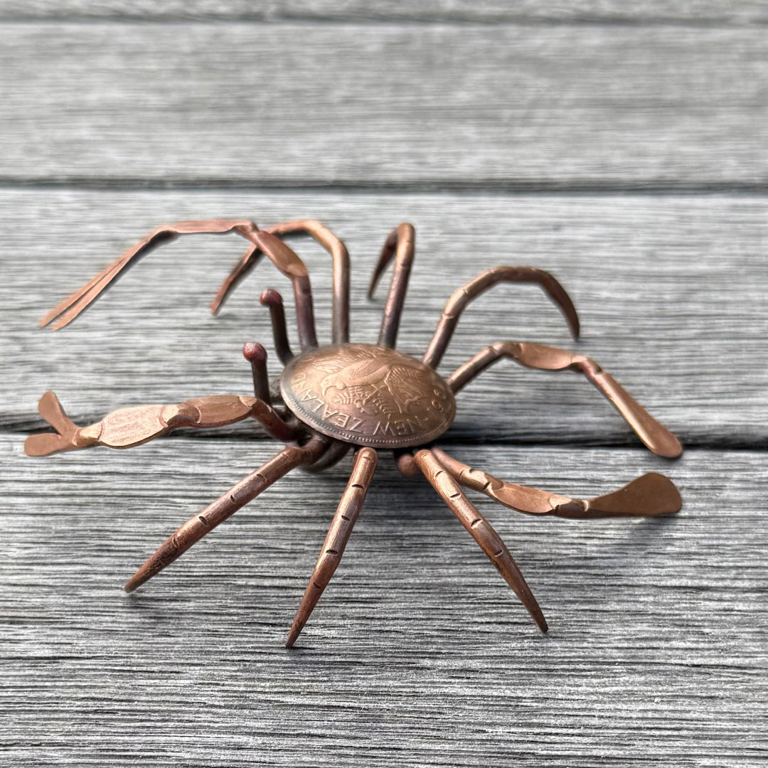 Copper crab sculpture on a wooden surface