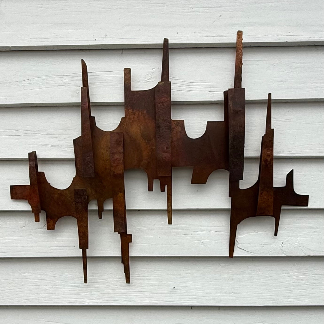 Copper wall sculpture on a white weatherboard background