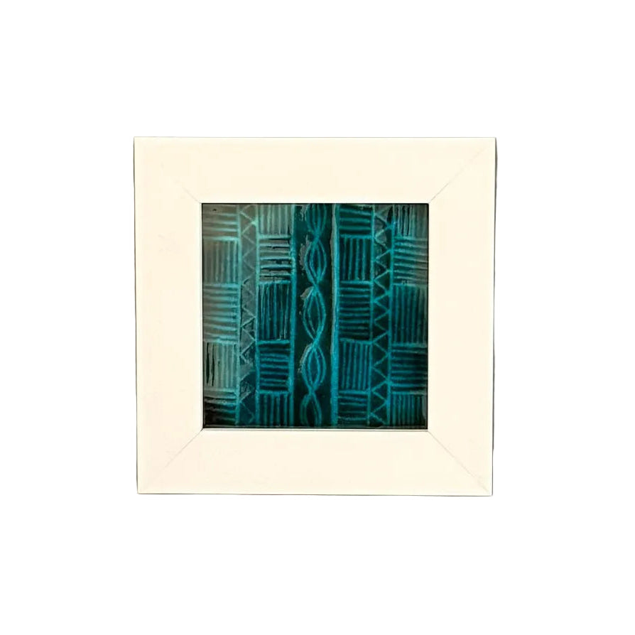 Framed artwork with a basket weave blue pattern on a white surface