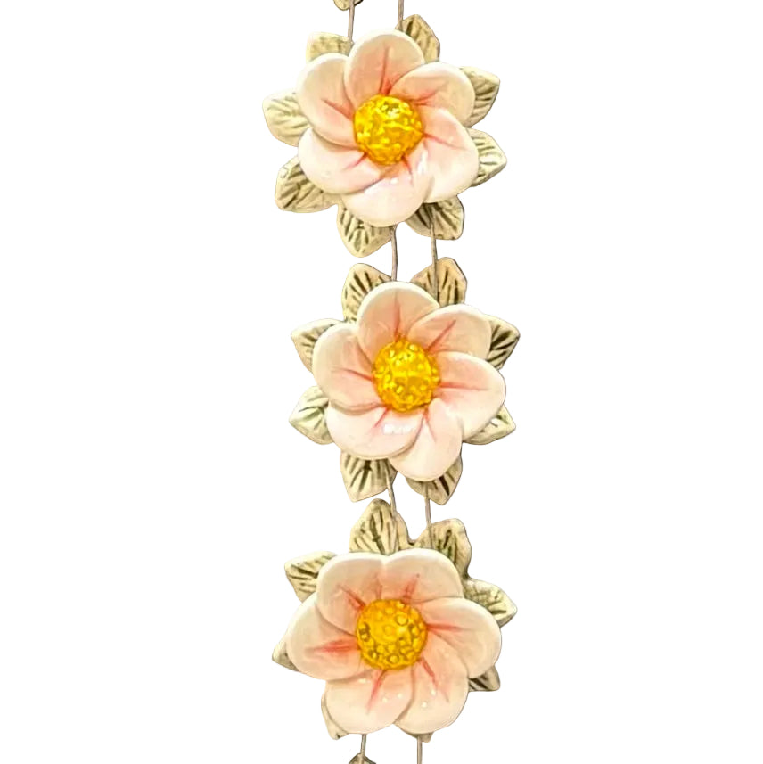 Decorative wall art close up of 3 pink flowers with yellow centers on a white background