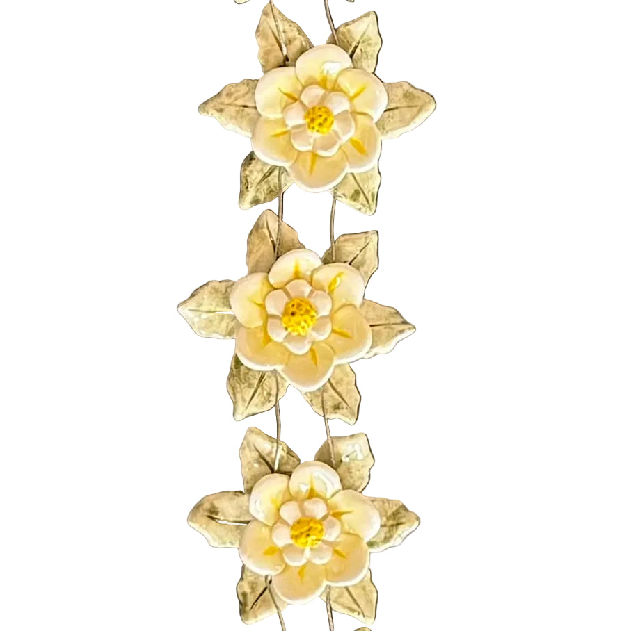 Close up of 3 ceramic flowers from a string of 5 wired vertically as a wall hanging on a white background