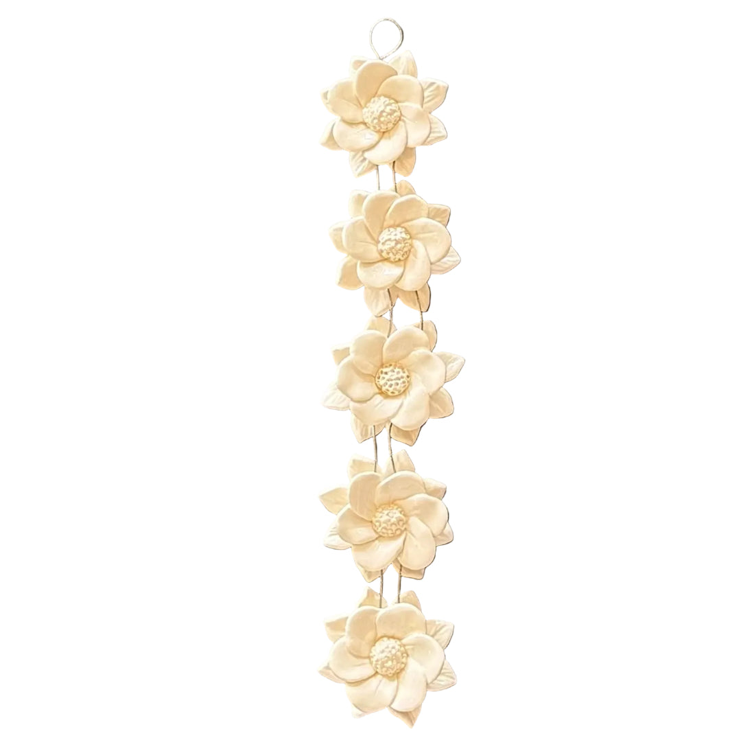 Decorative wall hanging with five white vertical ceramic wired flowers on a white background