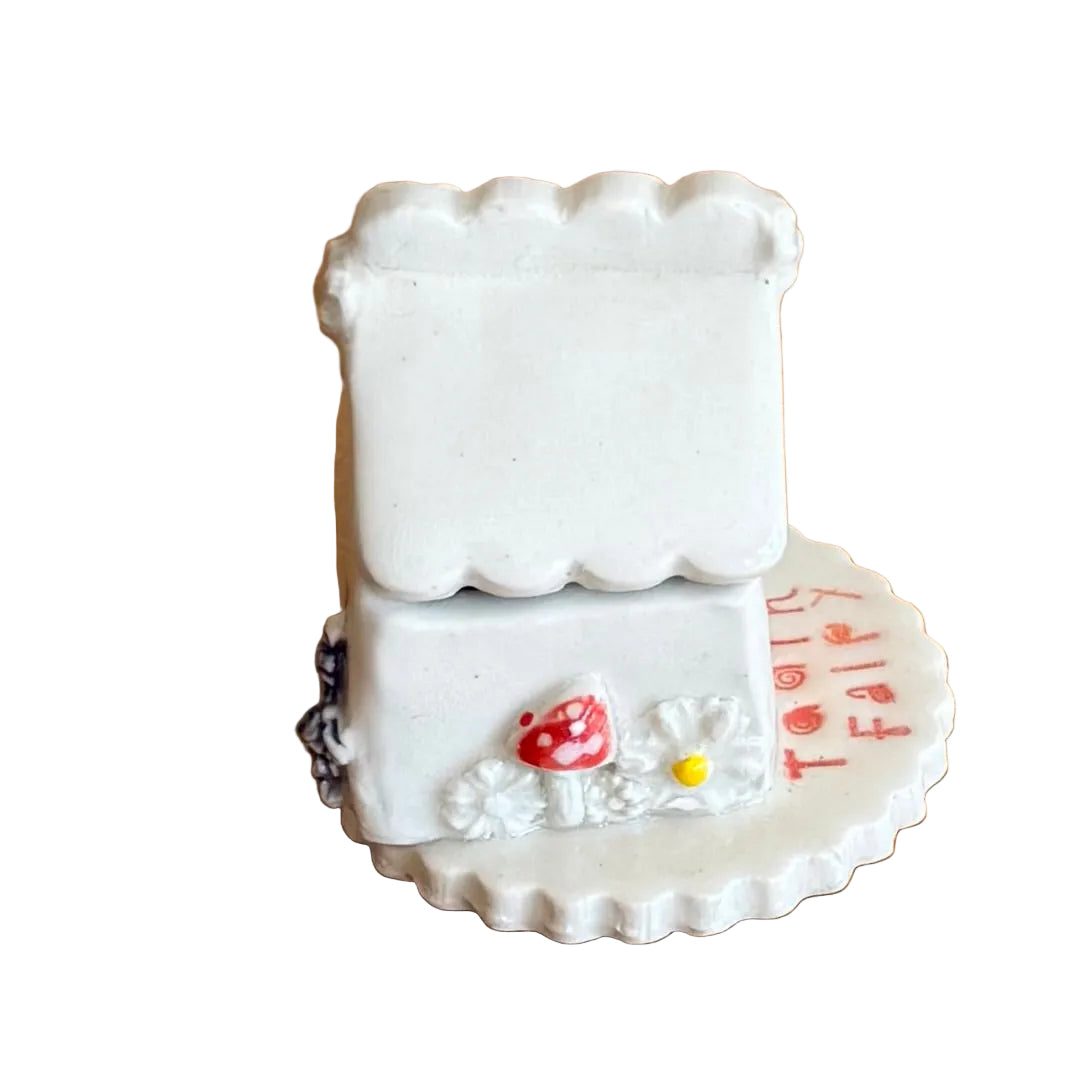 Decorative ceramic trinket box small house with 'Tooth Fairy' text on a white surface