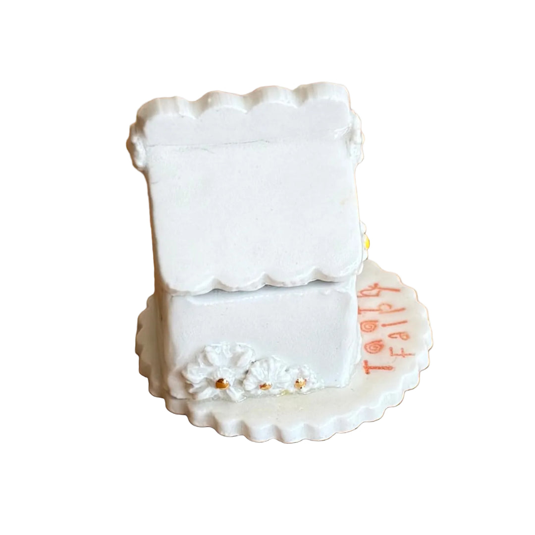 Decorative ceramic trinket box small house with 'Tooth Fairy' text on a white surface