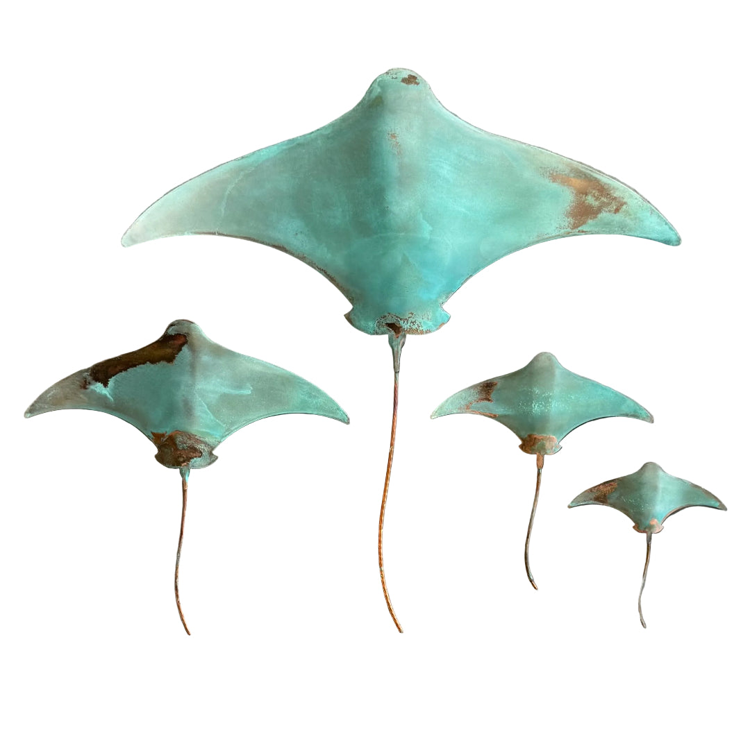 Four piece copper stingrays wall sculpture on a white background