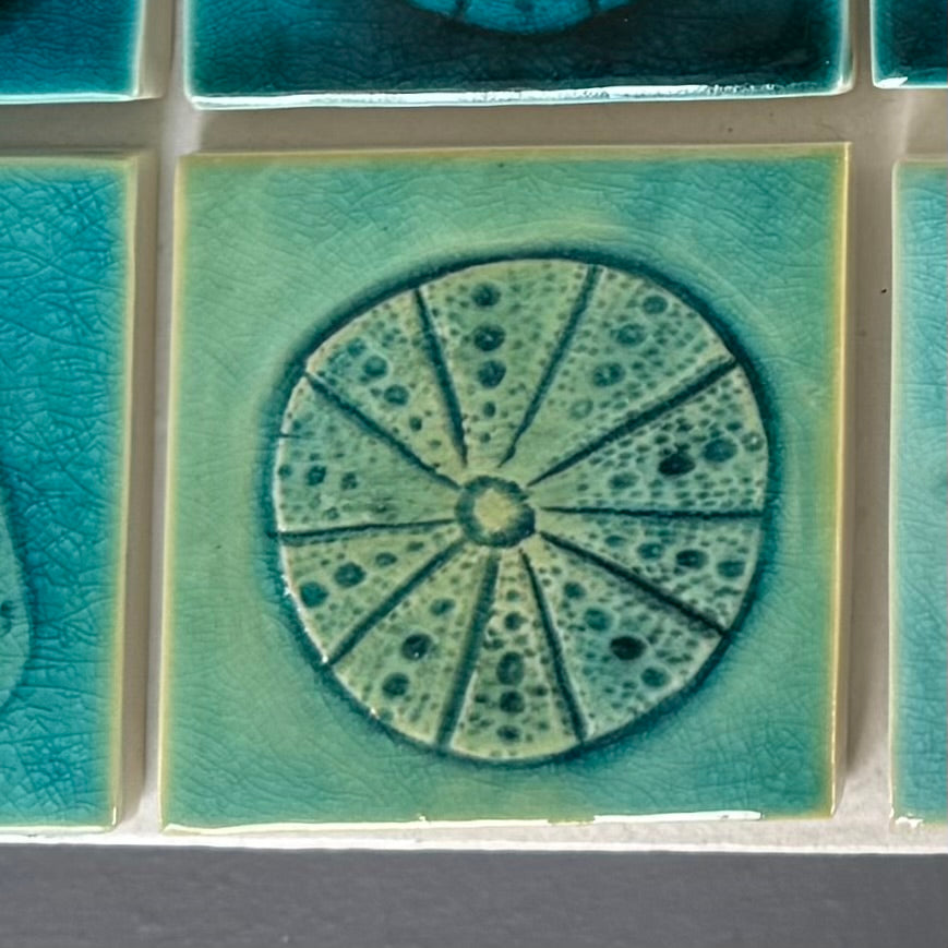 Close-up of a ceramic tile with a decorative pattern on a kina on a white background