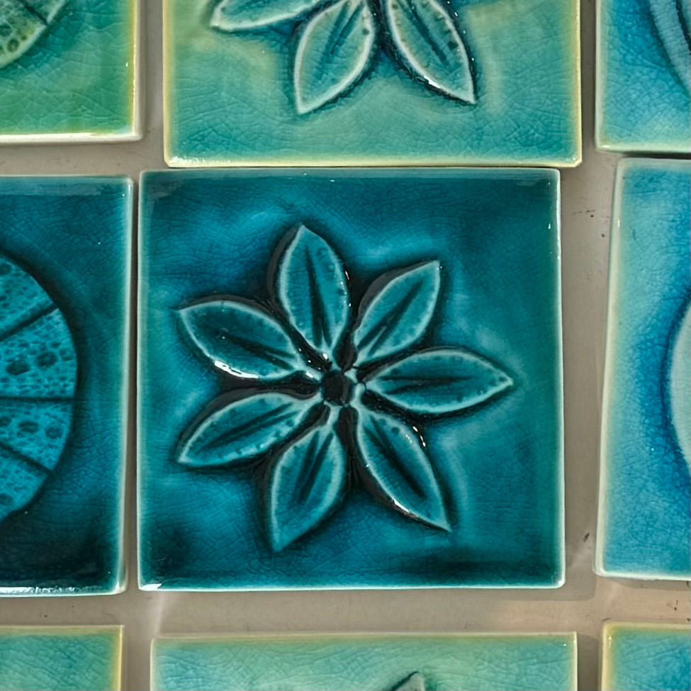 Close-up of teal ceramic tiles with floral patterns