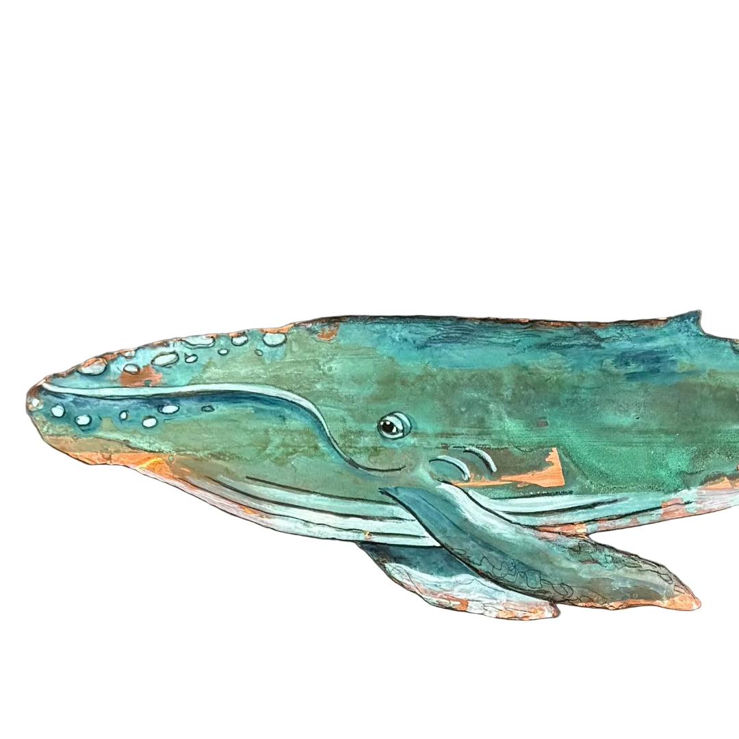 Decorative copper whale sculpture on a white background