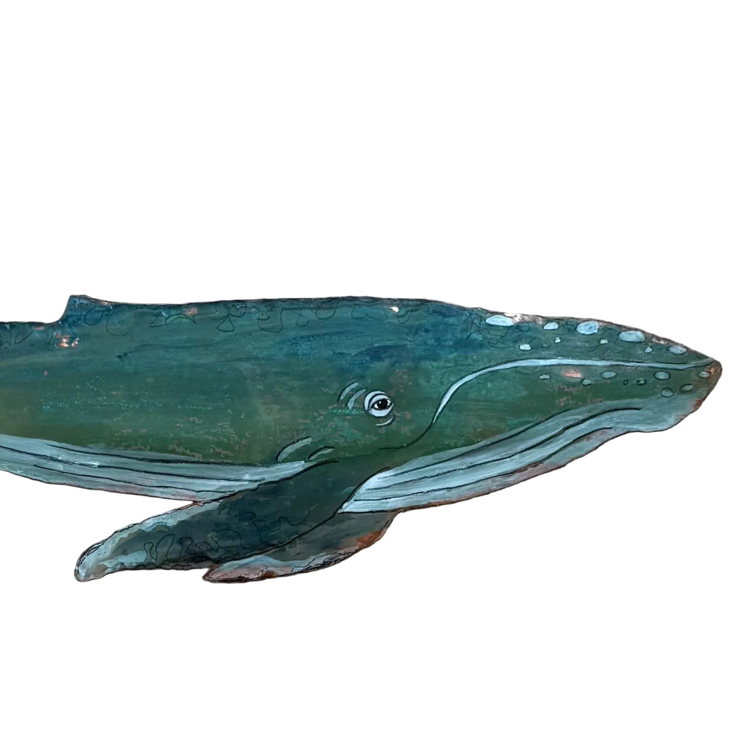 Close up of a copper whale wall sculpture on a white background