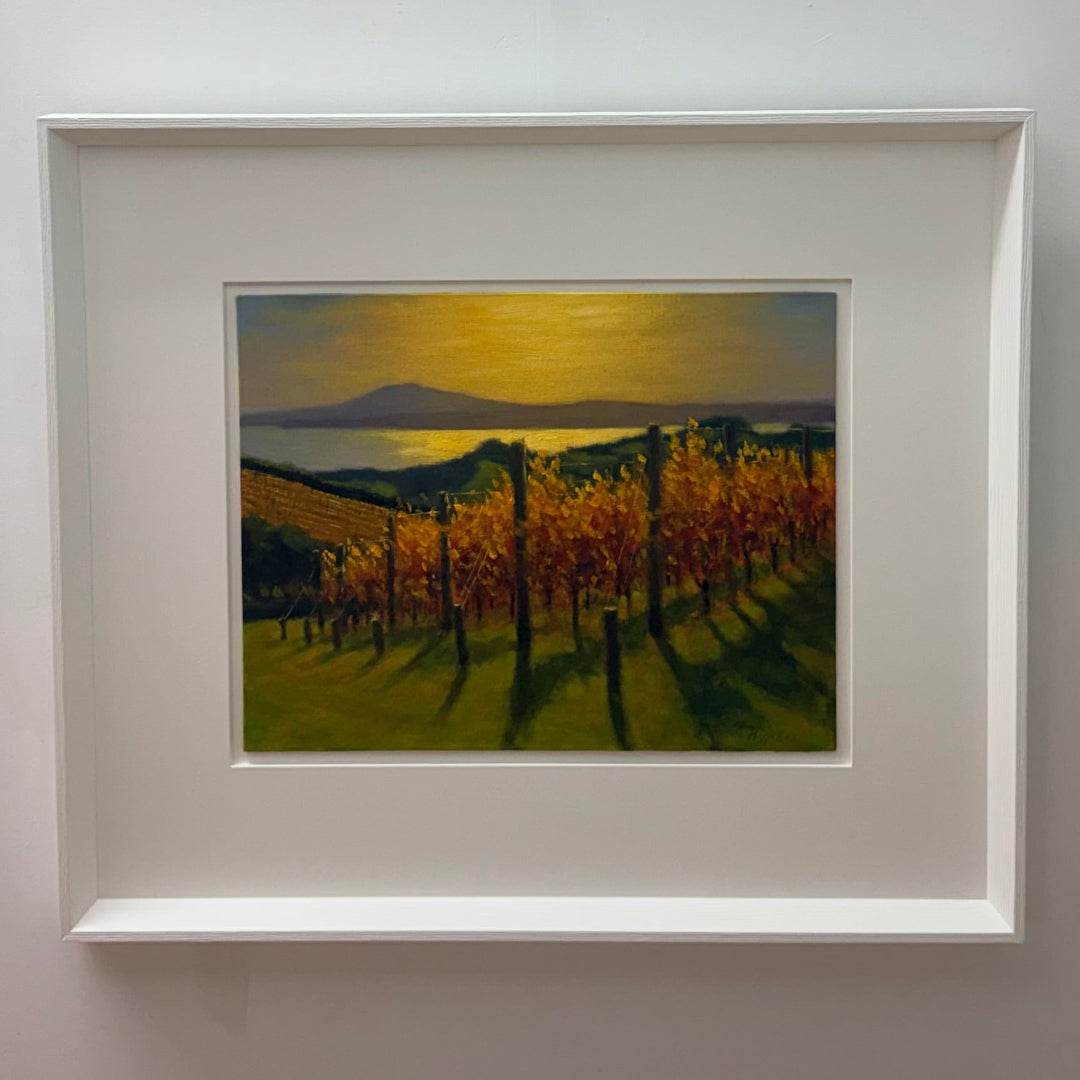 Framed painting of a vineyard landscape with mountains and sunset.