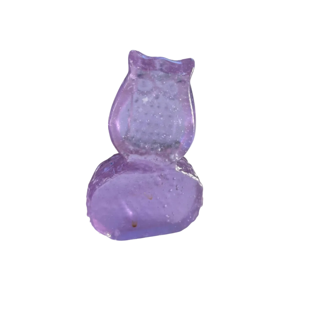 Back view of an amethyst coloured glass owl sculpture on a white surface