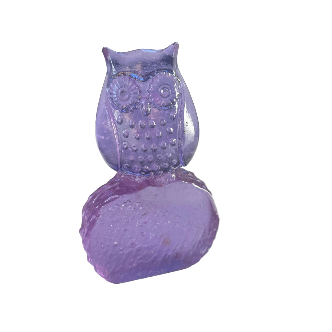 Amethyst coloured glass owl sculpture on a white surface