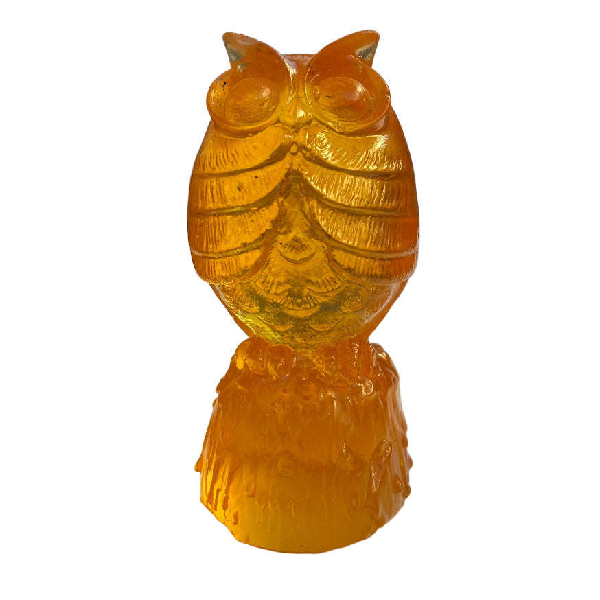 Orange owl glass sculpture on a white surface