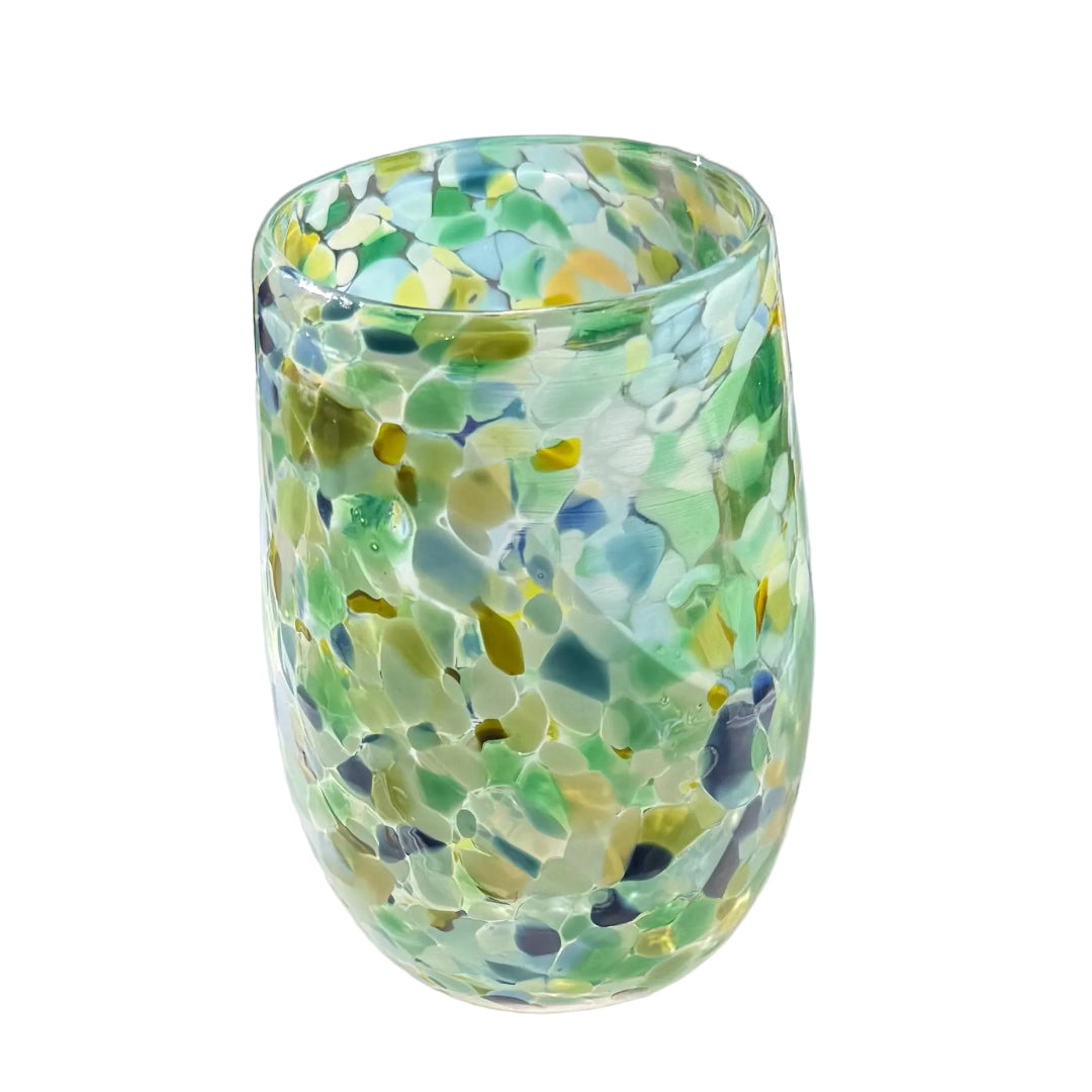 Colorful glass tumbler with a mosaic pattern on a white surface