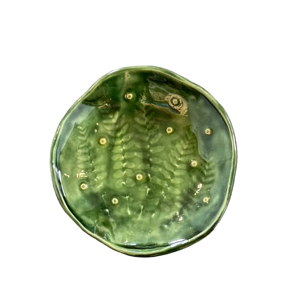 Green ceramic dish with textured surface on a white background