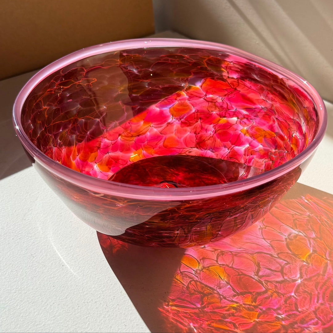 Pink & red glass bowl on a white surface