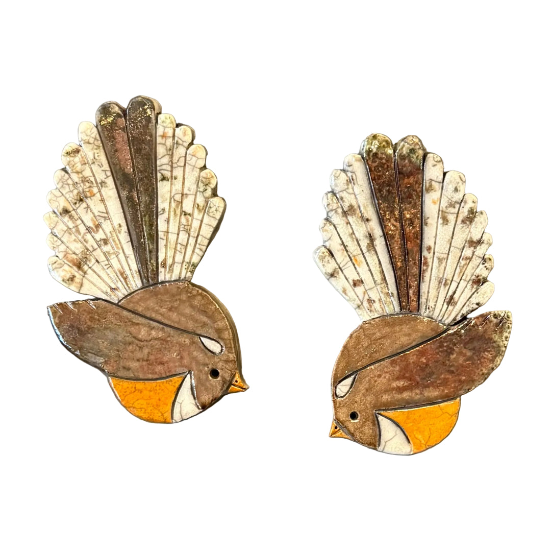 Two ceramic Fantail shaped wall tiles on a white background