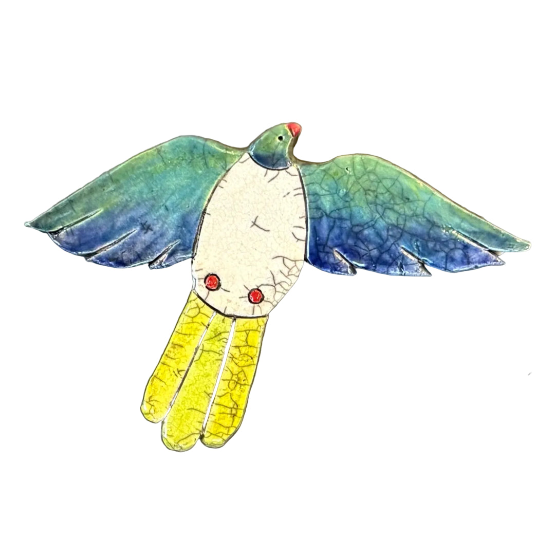 Colourful ceramic Kereru flying shaped wall tile on a white background