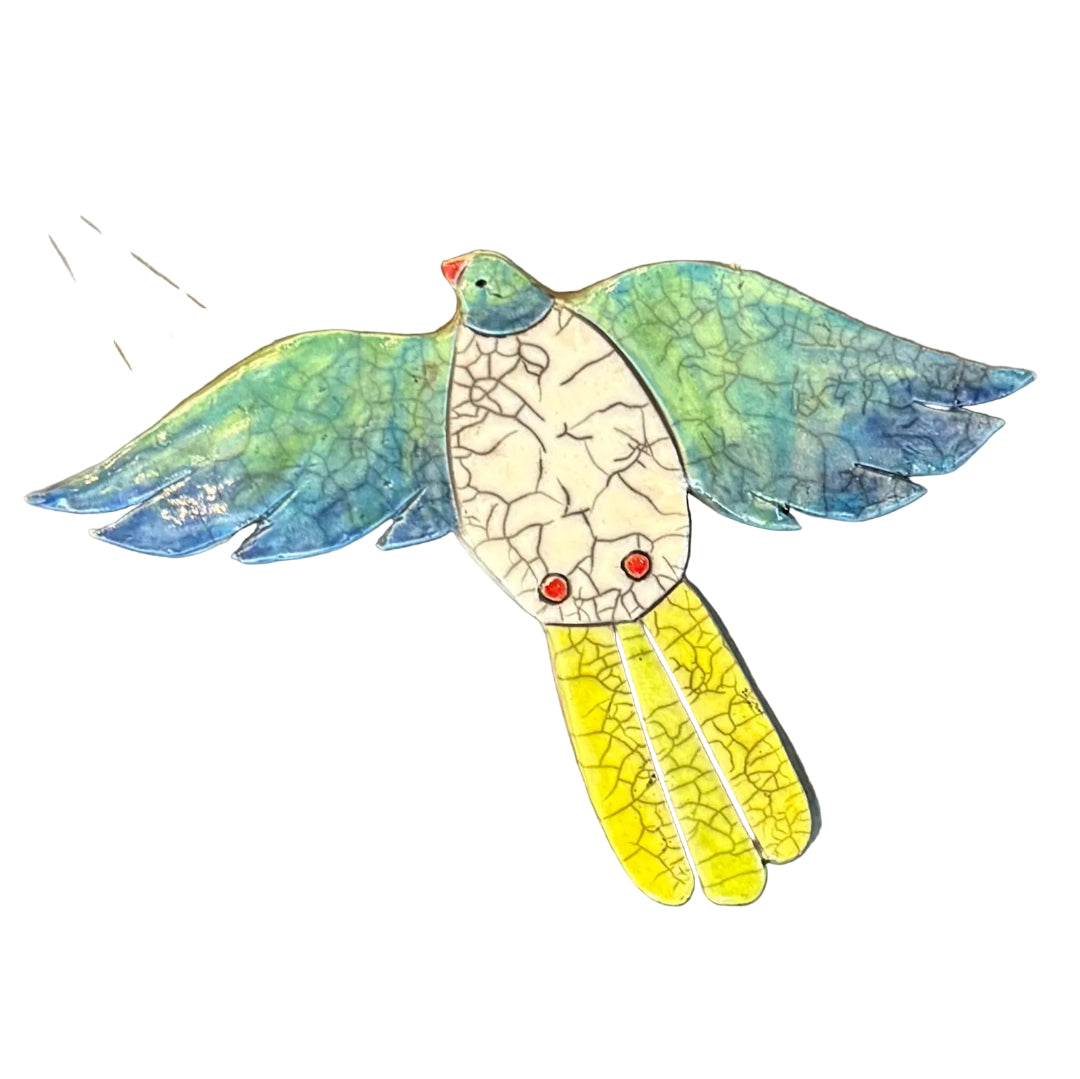 Colourful ceramic Kereru flying shaped wall tile on a white background