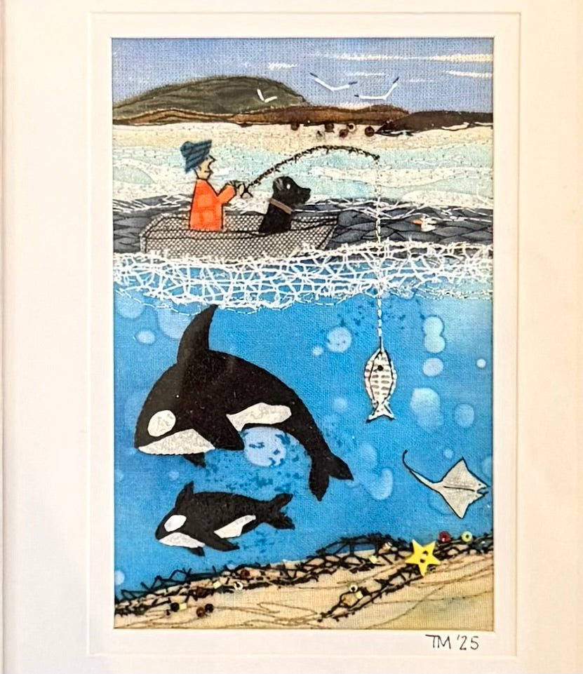 Textile artwork of a person fishing with a dog, surrounded by orcas and fish underwater.