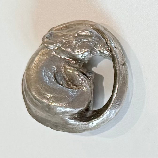 Silver plated cast bronze miniature mouse curled up on a white background